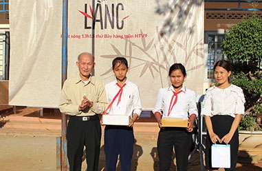 Chủ tịch Hội Khuyến học tỉnh Hà Ngọc Đào trao quà tặng em Lê Thị Thu Thảo (thứ hai từ trái sang) và các học sinh, giáo viên khó khăn. 