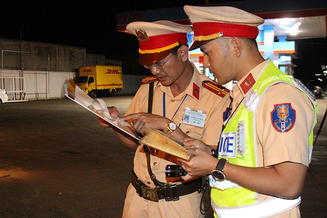 Cảnh sát giao thông kiểm tra kết quả cân trọng tải.  