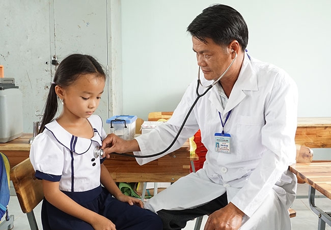 Bác sĩ của Trung tâm Y tế huyện Krông Bông khám sàng lọc cho trẻ em tại xã Cư Pui trong chiến dịch tiêm viêm não Nhật Bản.