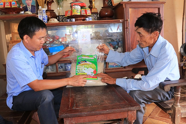 Ông Đoàn Văn Ương (bên phải) cùng cán bộ Phòng NN-PTNT huyện Lắk kiểm tra chỉ dẫn địa lý của thương hiệu Gạo Sạch Đồng Nhất.