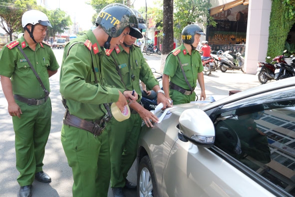 Lực lượng chức năng niêm phong để thực hiện cưỡng chế 1 ô tô đỗ tại ngã tư Phan Bội Châu – Hai Bà Trưng (TP. Buôn Ma Thuột). 