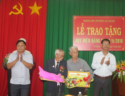 Lãnh đạo Huyện ủy Cư Kuin trao tặng Huy hiệu Đảng cho các đảng viên 70 năm tuổi Đảng. 