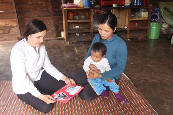 Chị  H’Lin Mlô (bìa trái) tuyên truyền cách phòng, chống  dịch sốt  xuất huyết  cho gia đình chị  H’Mon Niê ở  buôn Tlan. 