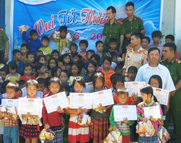 Cán bộ, chiến sĩ Công an huyện Krông Bông tặng quà cho các em thiếu nhi tại buôn Cư Dhiắt, xã Cư Drăm.