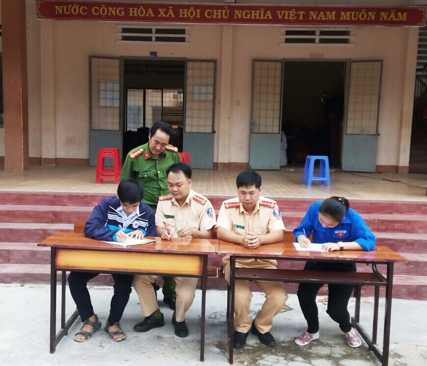 Đại diện học sinh Trường THPT Krông Bông ký cam kết không vi phạm Luật ATGT trong đợt tuyên truyền do Đội CSGT, Công an huyện tổ chức. 