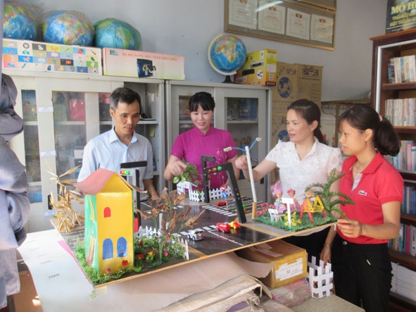 Cô Nguyễn Thị Hoa Mỹ  (thứ hai từ trái sang) kiểm tra mô hình  vật chất phục vụ giảng dạy. 