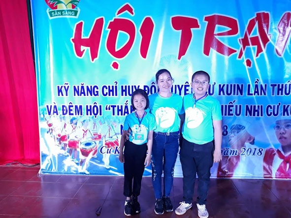            Cô Ngô  Phương Thúy (giữa) và  học sinh  tại Hội trại  kỹ năng  chỉ huy Đội giỏi huyện Cư Kuin năm 2018.  