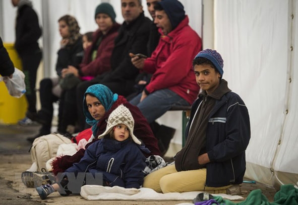 Người di cư chờ làm thủ tục tại trung tâm đăng ký lưu trú ở Berlin, Đức ngày 15-10-2015. (Ảnh: AFP/TTXVN)
