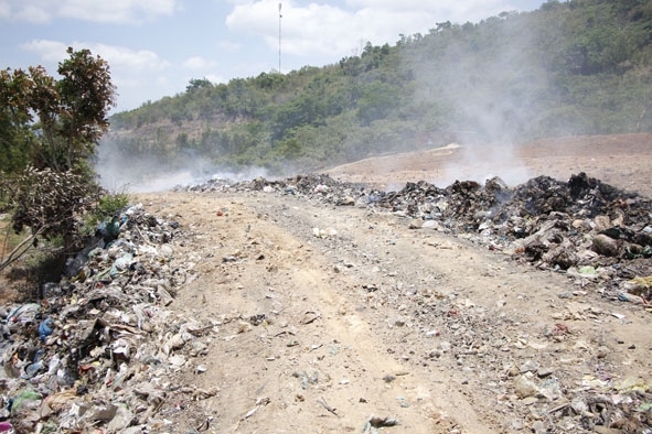 Rác thải dọc lối đi lên bãi rác tập trung xã Ea Ô được đơn vị quản lý đốt, gây ô nhiễm khói, bụi và mùi hôi.
