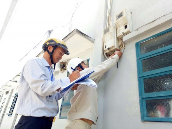Nhân viên Công ty Điện lực Đắk Lắk kiểm tra hệ thống đo đếm điện tại một khu phòng trọ  ở TP. Buôn Ma Thuột.
