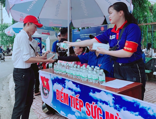 Thanh niên tình nguyện phát nước uống miễn phí cho các thí sinh tại điểm thi  Trường THPT Krông Bông. 