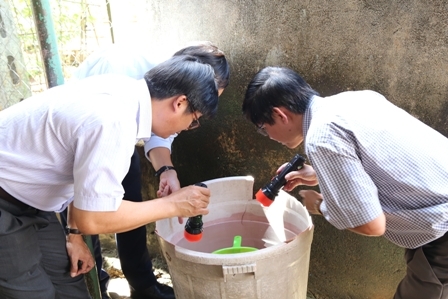 Đoàn công tác kiểm tra lăng quăng trong dụng cụ chứa nước tại một hộ dân trên địa bàn phường Ea Tam