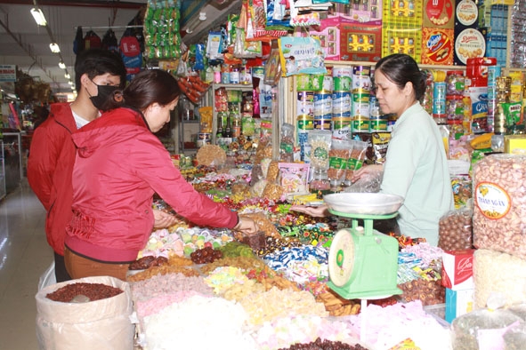 Người tiêu dùng chọn mua bánh kẹo tại chợ Buôn Ma Thuột.  