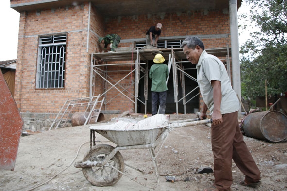 Ông Y Túk Ađrơng (đảng viên chi bộ buôn Ea Bông, xã Ea Kao) đang vận chuyển vật liệu để làm nhà. 