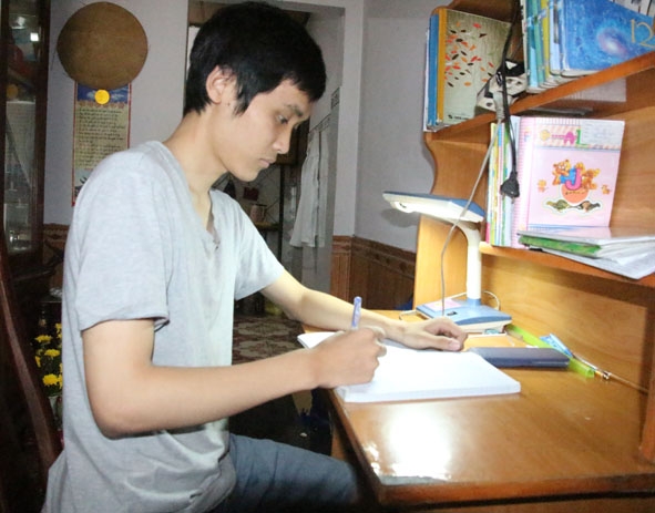 Em Lê Thanh Minh bên góc học tập của mình.