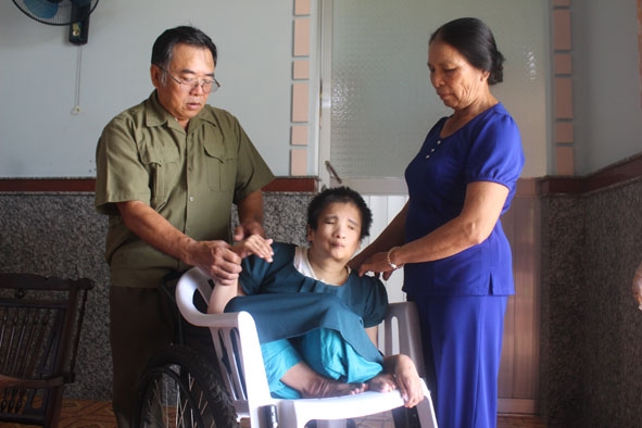 Vợ chồng ông Nguyễn Văn Thiện  (thôn 8, xã Ea Đar, huyện Ea Kar) chăm sóc người con bị nhiễm chất độc da cam. 