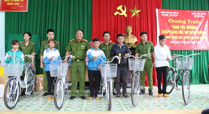 Đại diện Phòng Cảnh sát kinh tế (Công an tỉnh) trao xe đạp cho các em học sinh buôn Đắk Sar.