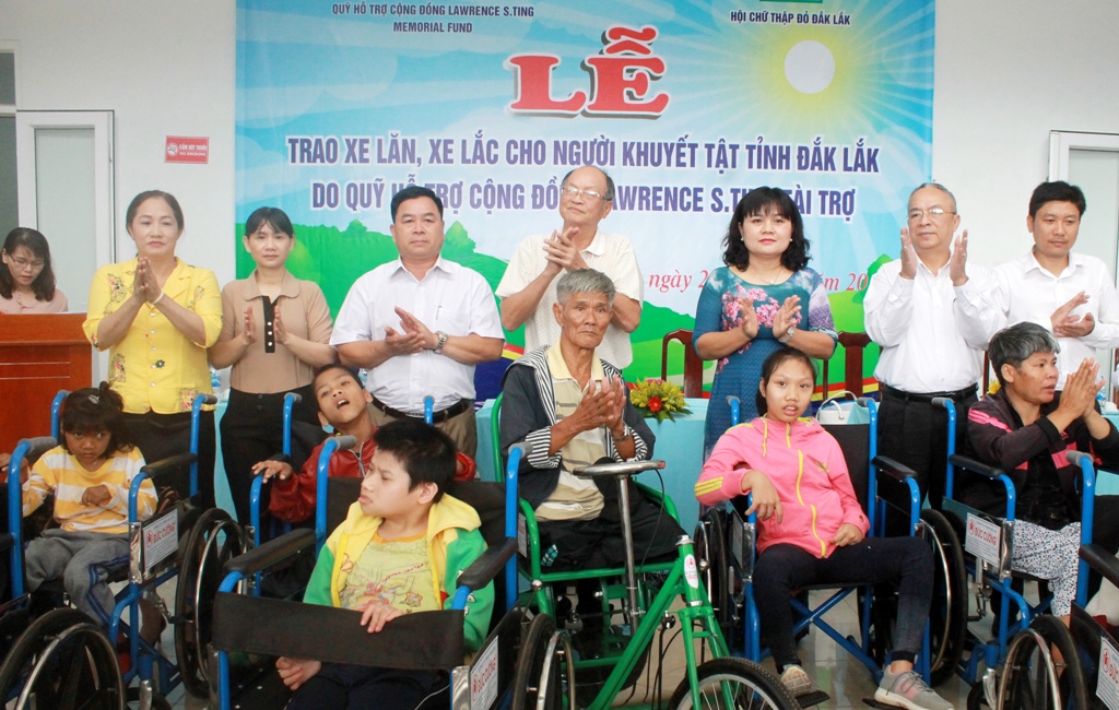 Phó Chủ tịch UBND tỉnh H’Yim Kđoh, đại diện các sở, ban, ngành cùng đại diện Quỹ hỗ trợ cộng đồng Lawrence S.Ting trao xe lăn, xe lắc cho đại diện người khuyết tật trên địa bàn.
