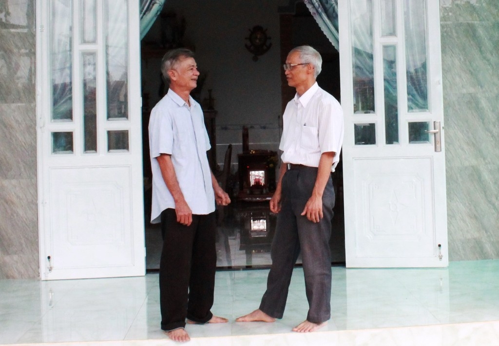 Ông Bùi Quang Thuyết (bên trái) vui mừng trong ngôi nhà mới được hỗ trợ xây dựng.