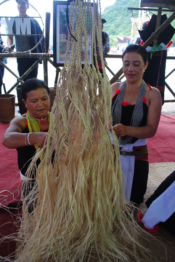 Bà Hồ Thị Chơn truyền nghề đan võng cho con gái mình. 