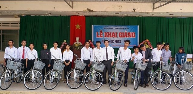 Các đại biểu trao tặng xe đạp cho học sinh nghèo vượt khó tại Lễ khai giảng. 