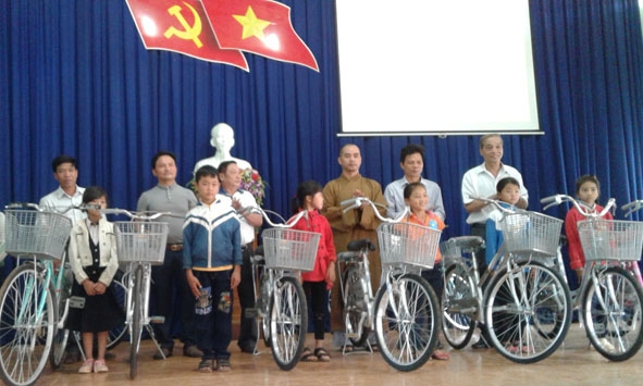 Đại diện  Hội Khuyến học xã Cư Ni trao xe đạp tặng học sinh nghèo  vượt khó  học giỏi. 