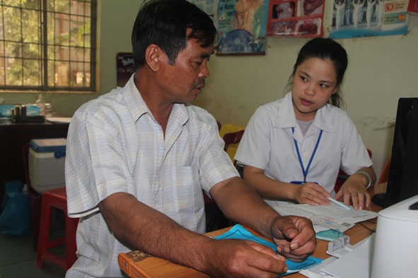 Y sĩ  Trạm Y tế xã Hòa Thuận (bìa phải) tư vấn chăm sóc sức khỏe cho người dân.  