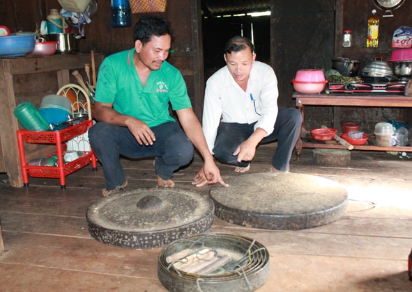 Anh Y Sai (bên trái) giới thiệu bộ chiêng cổ gia đình đang lưu giữ. 