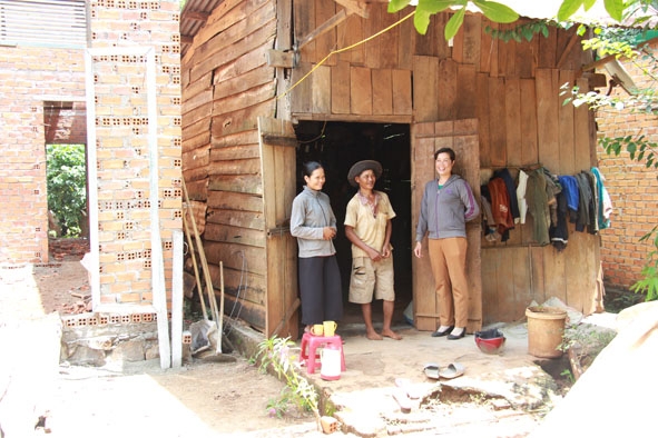Chị H’Yer Knul, ở buôn Dhăm, xã Ea Bông (bìa phải) đến thăm một gia đình trong buôn vừa được hỗ trợ xây dựng nhà 167.