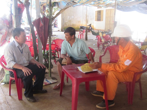 Nhân viên Công ty Điện lực Đắk Lắk làm việc với khách hàng có công trình vi phạm hành lang tại xã Ea Ktur, huyện Cư Kuin.