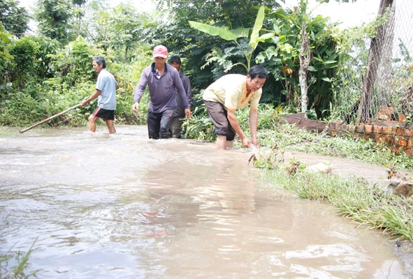 Sau khi mưa lớn ngớt người dân thôn 5, xã Ea Bar đã tập trung ra đường khơi thông dòng chảy.