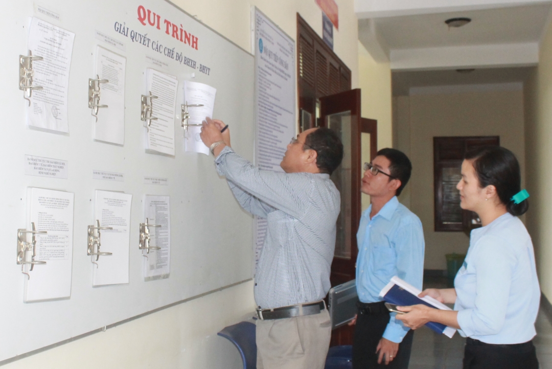Thành viên Đoàn kiểm tra kiểm tra hoạt động công khai TTHC tại Bộ phận tiếp nhận và trả kết quả TTHC của BHXH huyện Cư Kuin. 