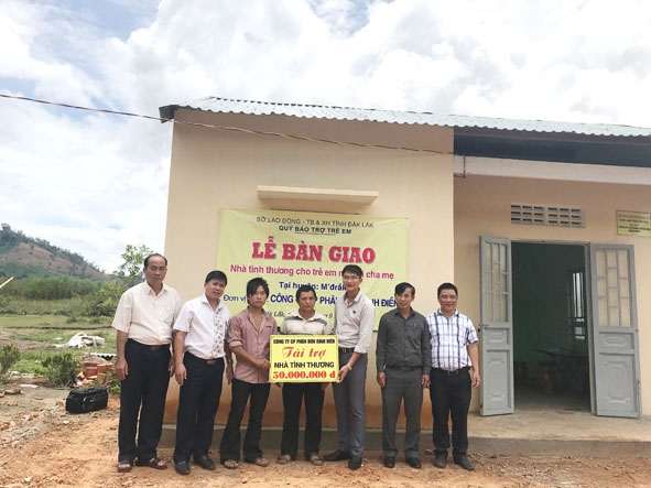 Đại diện các đơn vị trao bảng tượng trưng tài trợ xây nhà cho gia đình em Sùng Xuân Thái.  