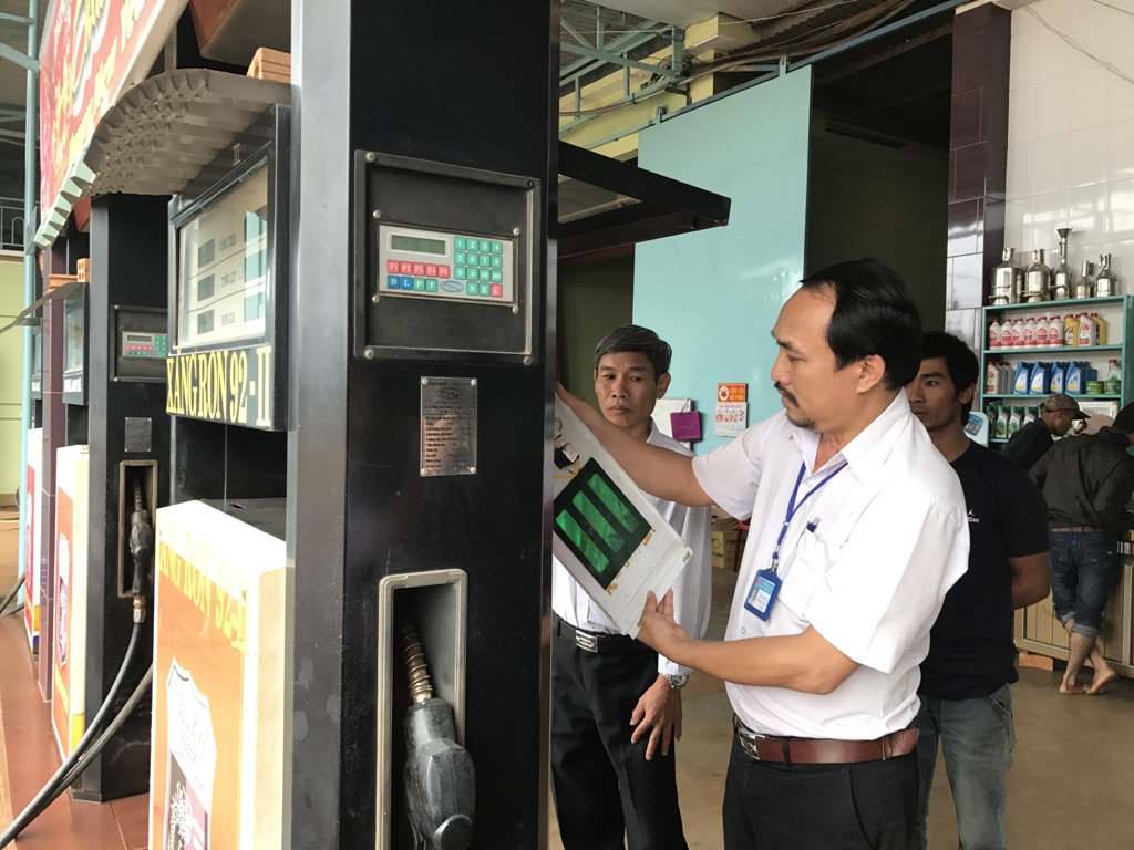 Cán bộ Chi cục Thuế huyện Cư M'gar kiểm tra tem niêm phong cột bơm xăng của một doanh nghiệp trên địa bàn