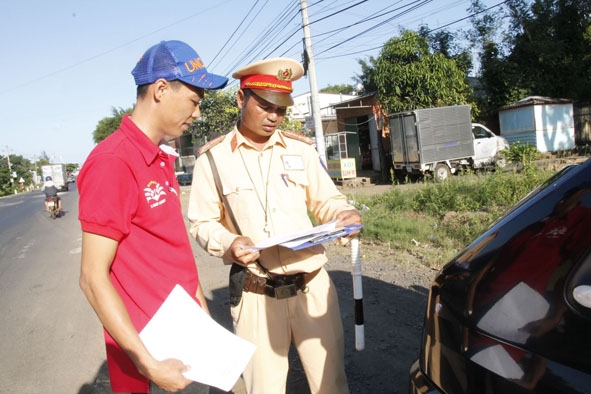 Cảnh sát giao thông Công an tỉnh kiểm tra giấy tờ liên quan của tài xế xe khách.   