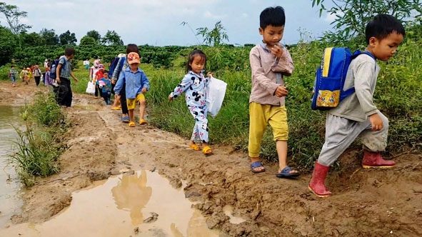 Để đến lớp, các em học sinh ở điểm trường Đắk Sar phải đi bộ trên con đường lầy lội. 