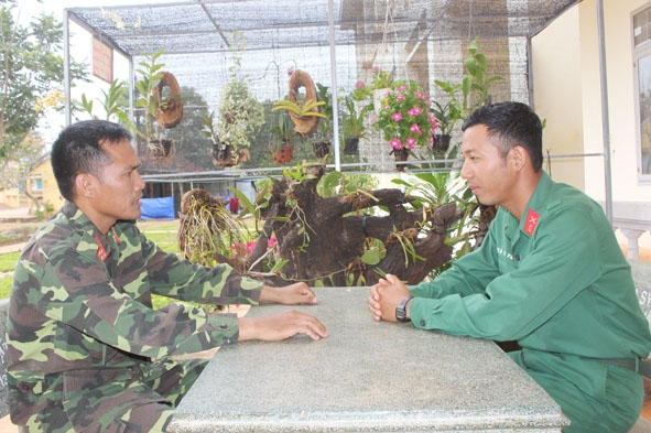 Hạ sĩ Mlô Y Yức  (bìa phải)  báo cáo công việc  với Đại úy Ralan Huỳnh - Chính trị viên Tiểu đoàn 303. 