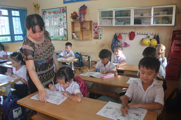 Cô Võ Thị  Thu Bình  luôn tận tình chỉnh sửa từng nét chữ, bài toán  cho học sinh. 