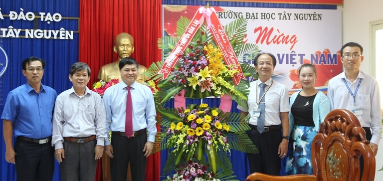 Phó Bí thư Thường trực Tỉnh ủy Phạm Minh Tấn tặng hoa và chúc mừng cán bộ, giáo viên Trường Đại học Tây Nguyên...