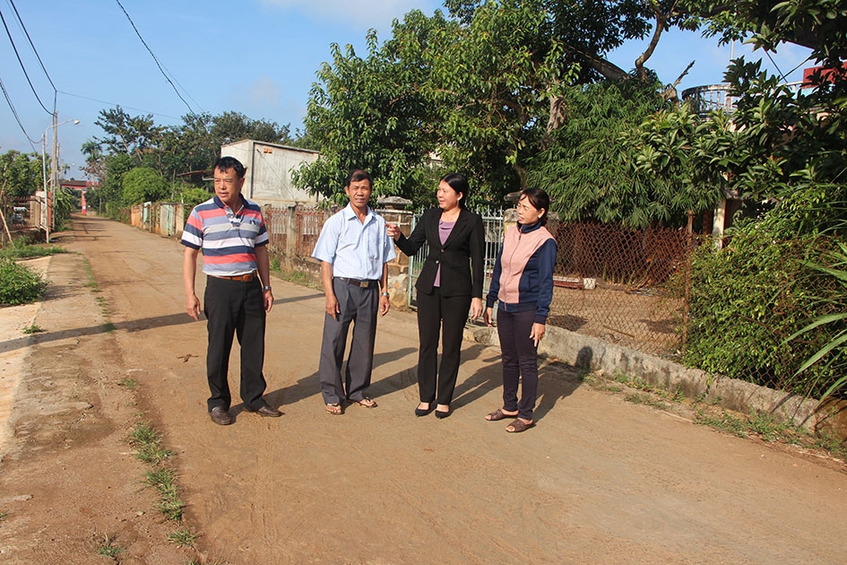 Chị Lê Thị Hồng Vân (thứ hai từ phải qua) trao đổi với Ban công tác Mặt trận thôn 8, xã Ea Tiêu về việc đóng góp kinh phí xây dựng đường giao thông.
