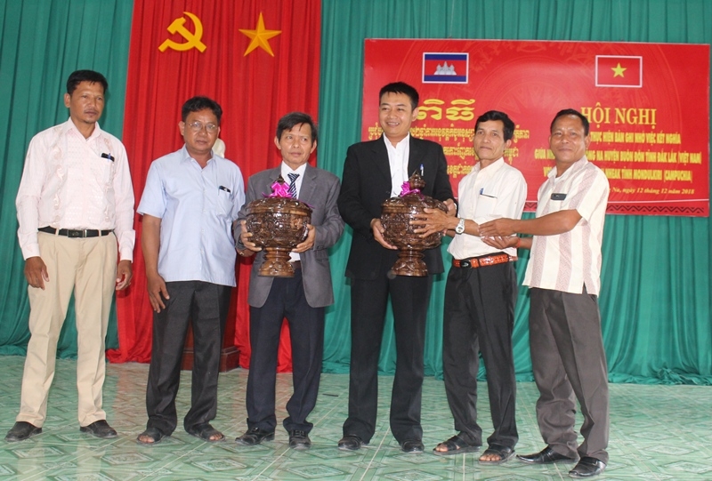 Đại diện chính quyền xã Sơ Rê Hui, huyện Kaok Nheaek (tỉnh Moldulkiri, Vương quốc Campuchia) tặng quà lưu niệm cho UBND xã Krông Na (huyện Buôn Đôn).