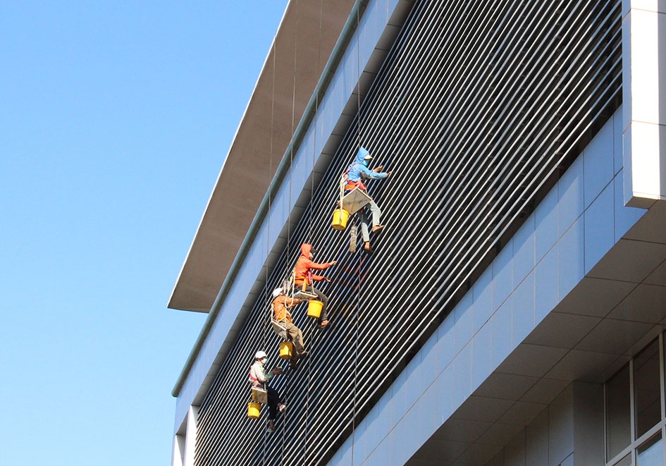 Nhóm thợ “đi dây” làm sạch bên ngoài một tòa nhà cao tầng tại TP. Buôn Ma Thuột.  