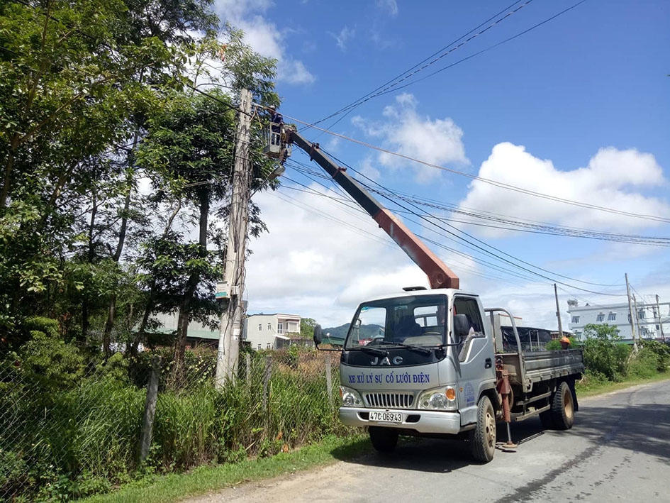 Công nhân HTX kinh doanh dịch vụ điện - nước huyện M’Đrắk kiểm tra lưới điện.  