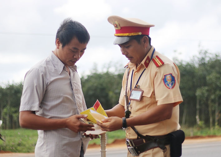 Thiếu tá Chữ Xuân Thủy kiểm tra giấy tờ người điều khiển phương tiện giao thông.