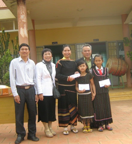 Ông Y Ly Niê Kdăm (bìa phải) và bà Linh Nga Niê Kdăm (thứ hai từ trái sang) là con của cố Nhà giáo Nhân dân Y Ngông Niê Kdăm, trao học bổng cho học sinh tại Trường Tiểu học Y Ngông (xã Dur Kmăl, huyện Krông Ana).