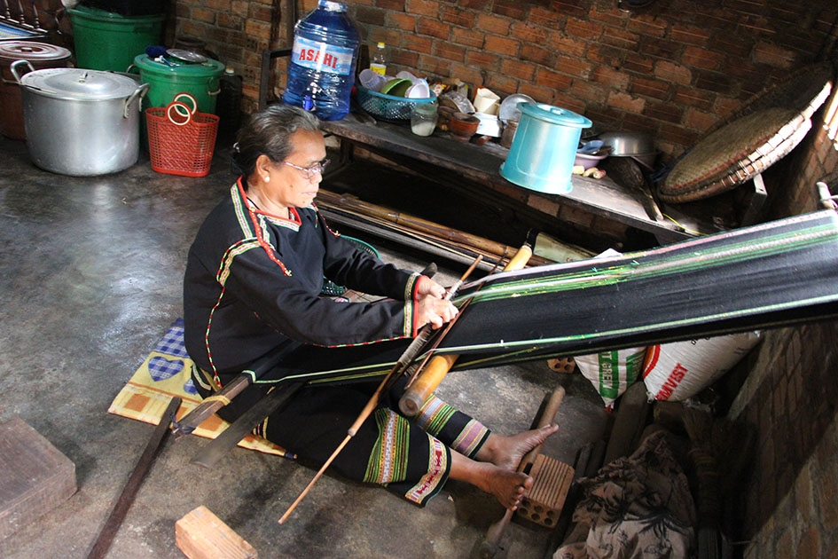 Bà H Wiêt Niê ở buôn Kplang (xã Tân Tiến, huyện Krông Pắc) bên khung dệt thổ cẩm. 