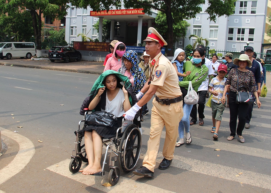 Cán bộ, chiến sĩ CSGT giúp người tàn tật qua đường an toàn. 