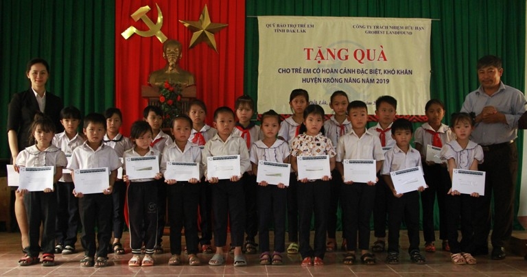 Đại diện Công ty TNHH Grobest Industrial Việt Nam cùng các đơn vị tặng học bổng cho học sinh nghèo vượt khó huyện Krông Năng. 