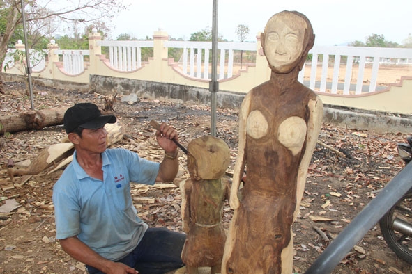 Anh  Su Wát Lut (dân tộc Lào) cùng  tác phẩm tạc tượng gỗ  dân gian 