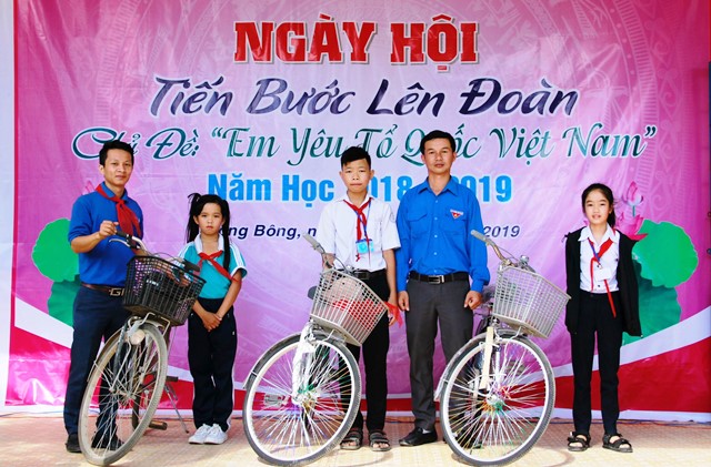 Đại diện Hội đồng Đội huyện Krông Bông trao xe đạp cho các em học sinh.